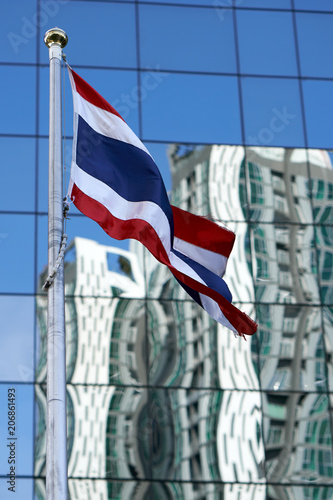 Thai flag in front of modern building.