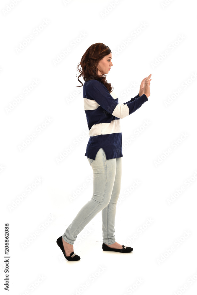 full length portrait of girl wearing striped blue and white jumper and jeans. standing pose on white studio background full length portrait of girl wearing striped blue and white jumper and jeans. standing pose on white studio background