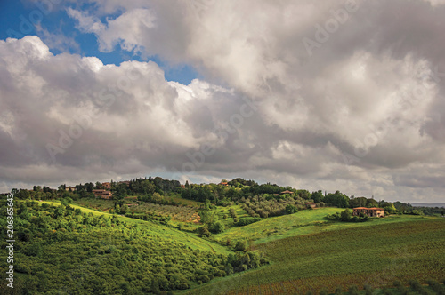 Overview of field, forests and hills with villa at the top in the Tuscan countryside, an unbelievable and traditional region in the center of the Italian Peninsula. Located near the city of Siena