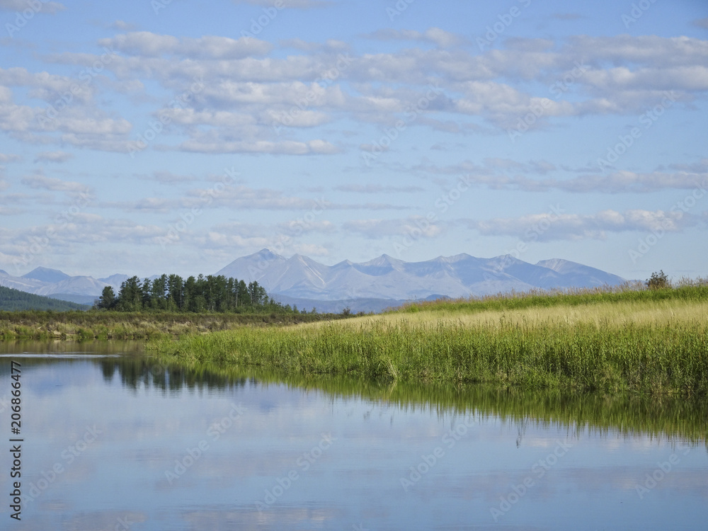 Landscape: calm river and mountains in the background
