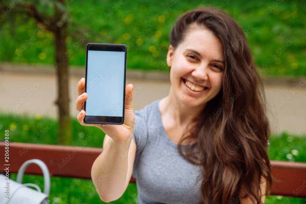 young adult woman showing phone with white screen. copy space