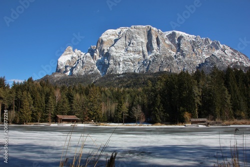 Iced Lago di Fié, view on Monte Sciliar, South Tyrol, Dolomites, Italy