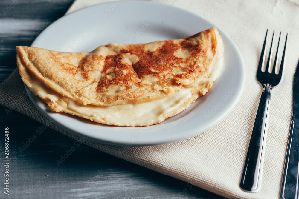 Crepioca - pancake of cassava (tapioca) with cheese on plate on wooden background. Selective focus Crepioca - pancake of cassava (tapioca) with cheese on plate on wooden background. Selective focus