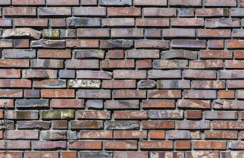 Close-up of a Brick wall. Decorative masonry using curves, non-standard bricks. Brick wall background. Horizontal orientation of the frame