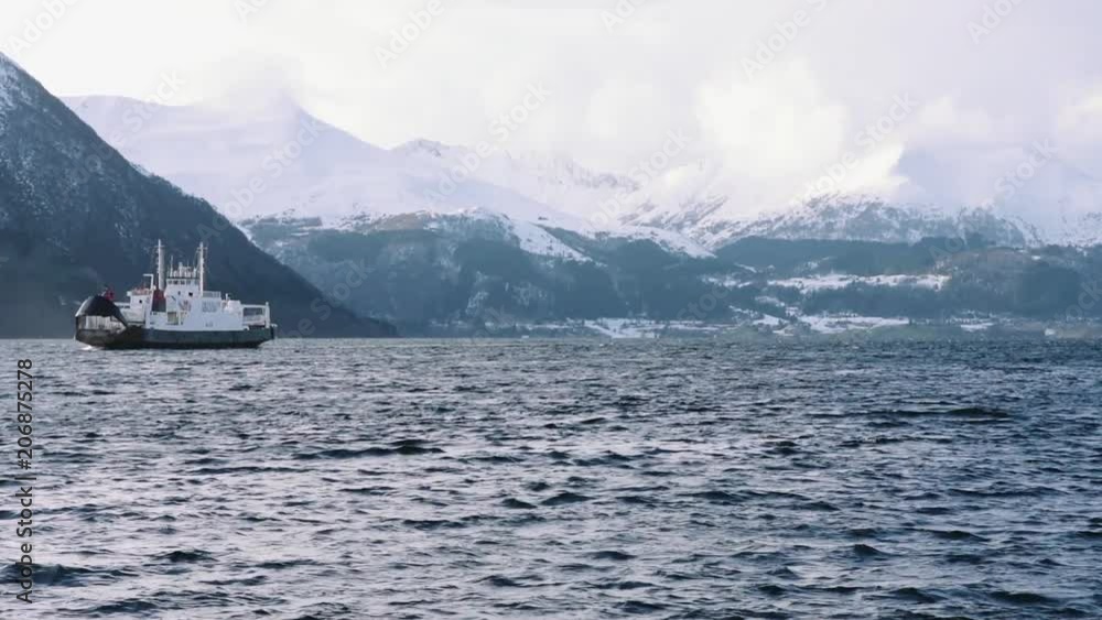 Ferry on the fjord with snow mountains, near volda (norway)