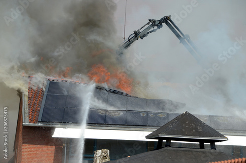 Fire in a building, firemen fight the fire.