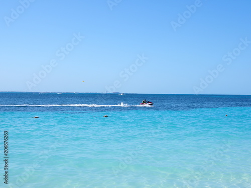 Panorama of clean turquoise waters of Caribbean Sea landscape with motor boat and horizon line at Cancun city in Mexico