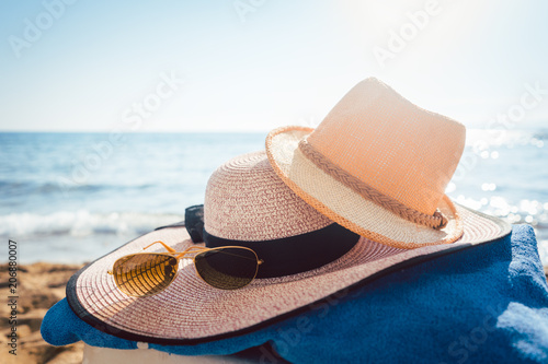 Foto Sun hats and glasses on beach in the sand by the water