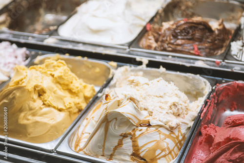 Different types of Italian natural gelato ice cream in showcase in pastry shop.