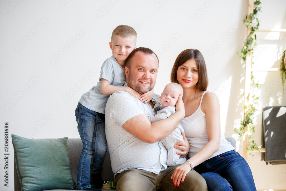 Picture of couple with two young sons sitting on sofa Picture of couple with two young sons sitting on sofa