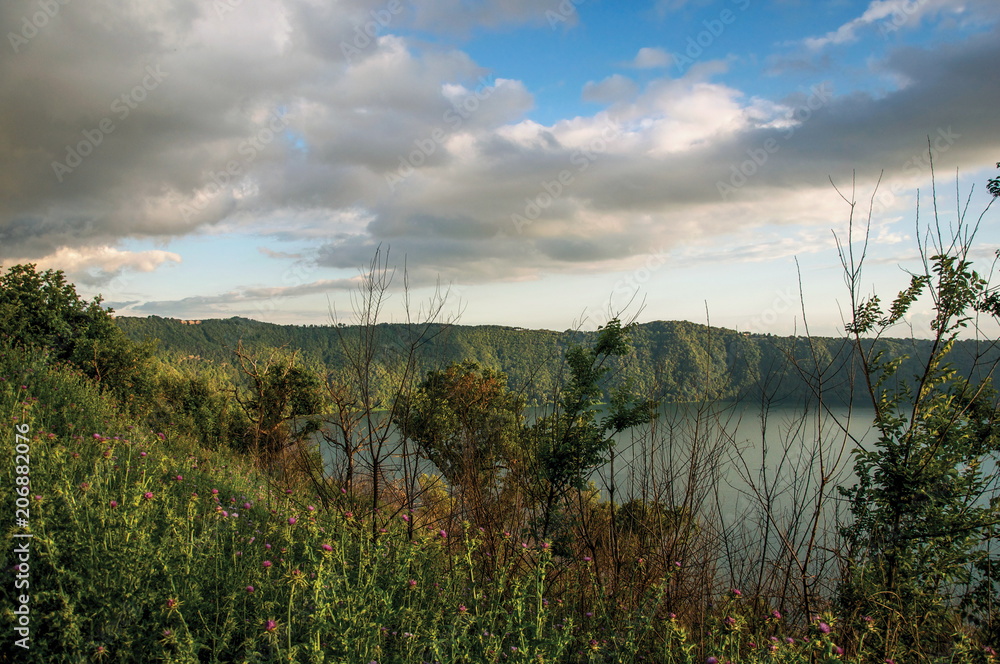 View of the slopes, forests and hills of Lake Albano in a cloudy sunset. Albano is a quiet and bucolic countryside region near Rome. Located in the Lazio region, central Italy