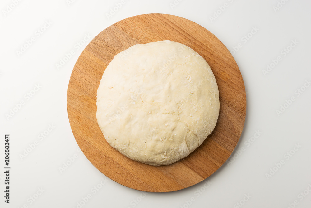 Fresh raw dough on wooden board isolated on white background Fresh raw dough on wooden board isolated on white background