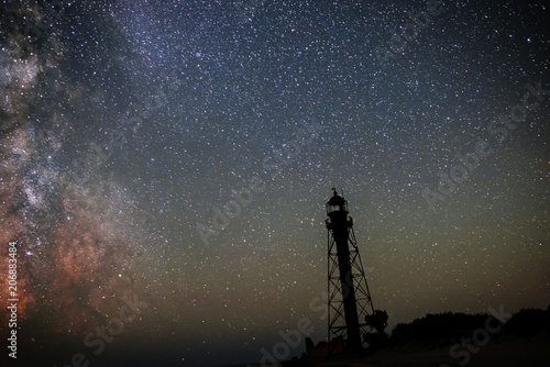 Silhouettes of the Old Lighthouse sandy beach and ocean against the background of the starry sky