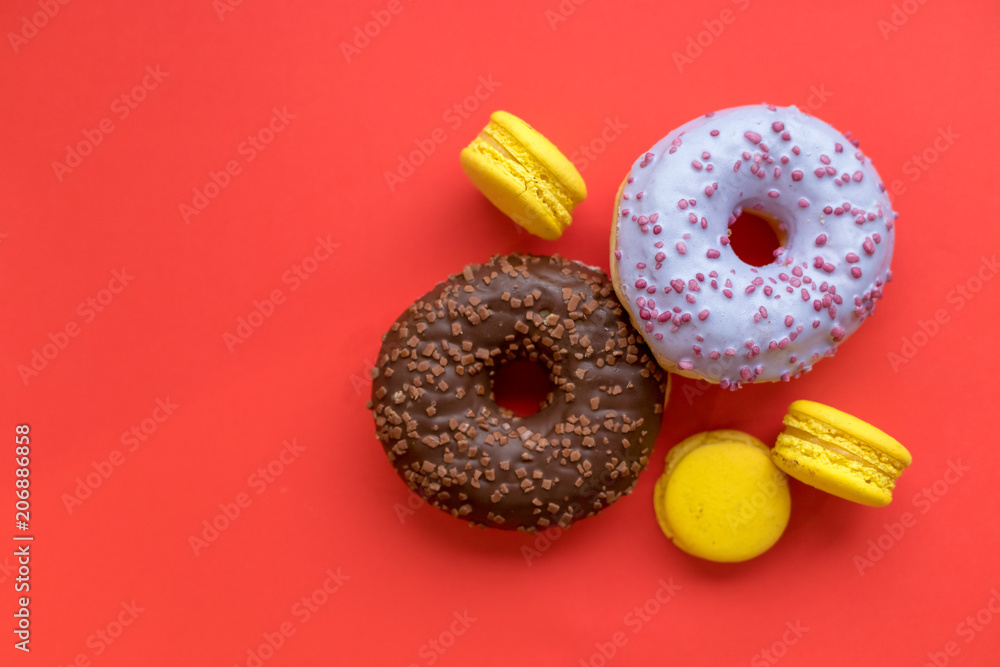 Seamless pattern made of macaroon and donut on the red background. Flat lay. Food concept. Unhealthy dessert. tasty sweet morning. Donuts and french delicious cakes isolated Seamless pattern made of macaroon and donut on the red background. Flat lay. Food concept. Unhealthy dessert. tasty sweet morning. Donuts and french delicious cakes isolated