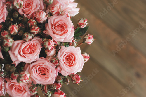 Pink Beautiful Roses Bouquet over Wooden Table. Top view Copy Space. Vintage Greeting Card © Inga
