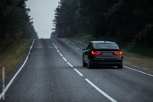 Asphalt road with car passing through the forest © pha88