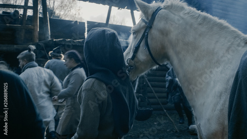 Medieval Reenactment. Life in the Yard of the Wooden Fortress, People with Horses. Assassin.