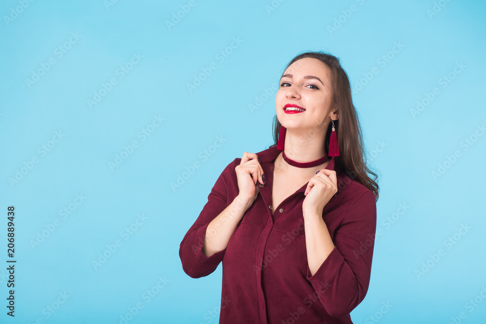 Confident girl smiling to camera. Portrait of woman over blue background Confident girl smiling to camera. Portrait of woman over blue background
