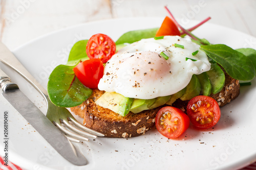 Healthy breakfast with avocado and poached egg toast
