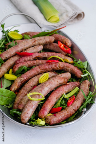 Grilled sausage with garlic and onions, greens.