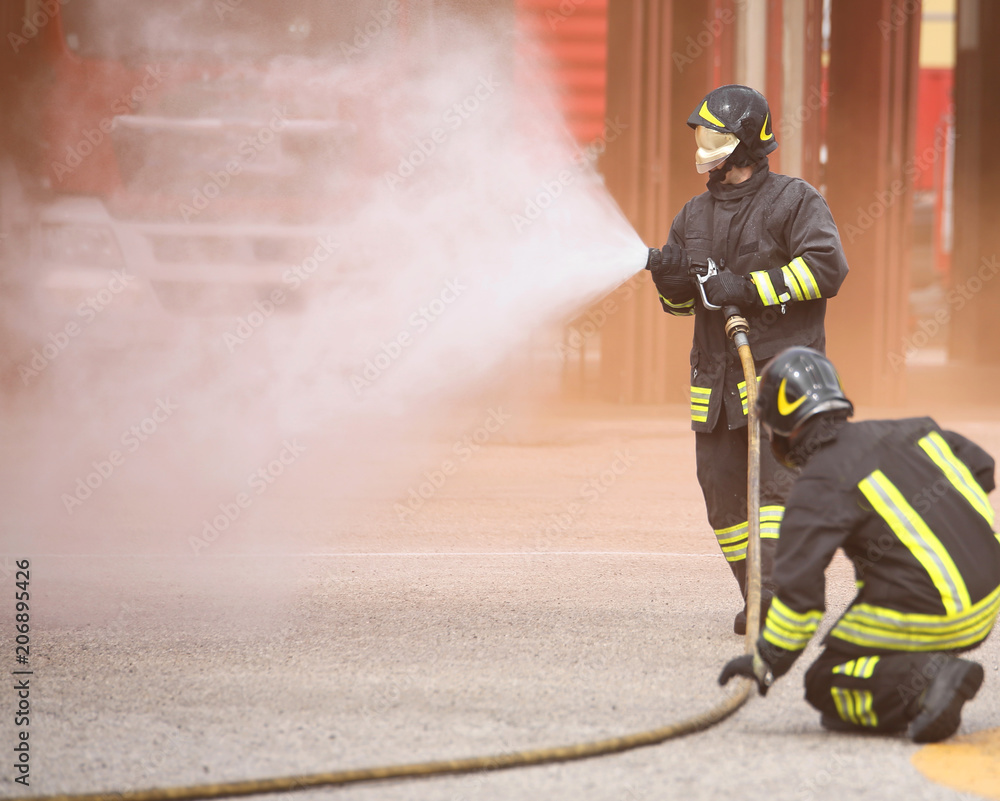 Obraz premium fireman with a mask extinguishes a fire