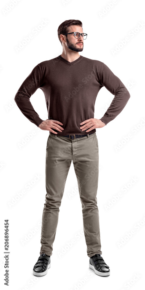 A bearded man in casual clothes stands with hands on his hips isolated on a white background. A bearded man in casual clothes stands with hands on his hips isolated on a white background.