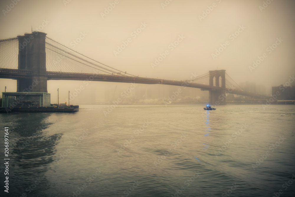 Fototapeta premium Brooklyn bridge at foggy rainy evening, New York City