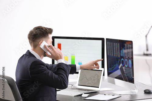 Male broker working in offi...