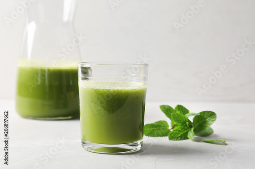 Glassware with delicious detox juice and mint on table
