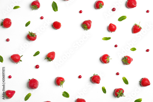 Flat lay composition with with tasty ripe strawberries, cranberries and mint on light background