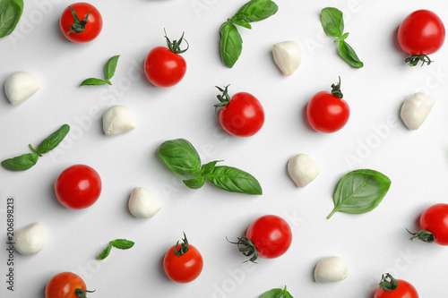 Flat lay composition with tomatoes  mozzarella cheese balls and basil on light background