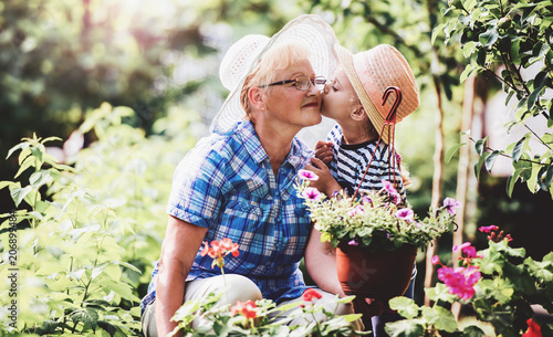 Gardening with kids. Senior woman and her grandchild working in the garden with a plants. Hobbies and leisure, lifestyle, family life
