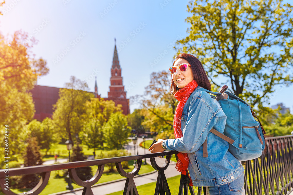 Attractive asian female traveler with backpack near Kremlin tower, Moscow tourism concept