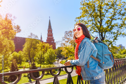 Attractive asian female traveler with backpack near Kremlin tower  Moscow tourism concept