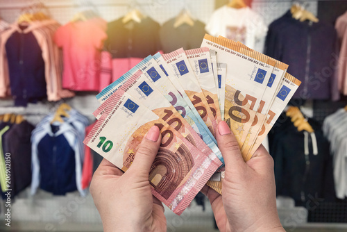 Shopping concept in dress store with euro in hands