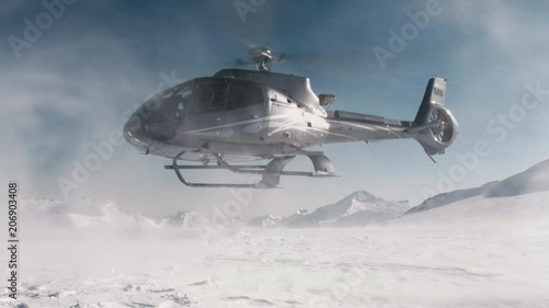 Black helicopter taking off from an alpine mountain with snow blowing in the wind