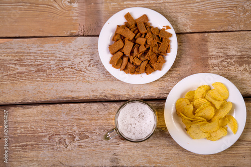 on a wooden table are white plates with crispy croutons and potato chips.