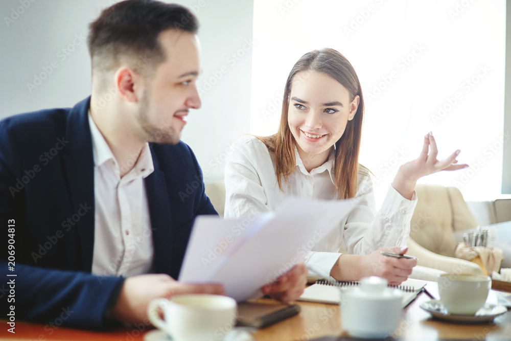 Businessman and businesswoman having friendly business talk at cafe. Business partners discussing report and planning strategy Businessman and businesswoman having friendly business talk at cafe. Business partners discussing report and planning strategy