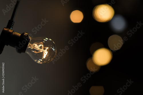 Light bulb on a wire with bokeh circles in the background