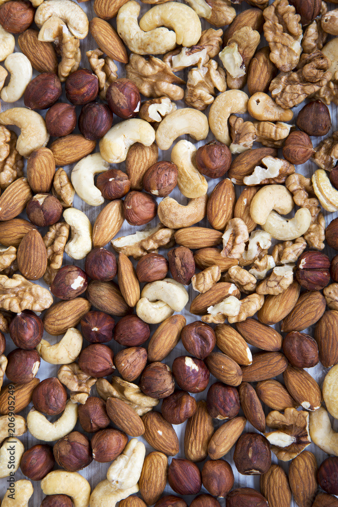 Mixed nuts (cashew, hazelnuts, walnuts, almonds) on white wooden background, top view. From above. Mixed nuts (cashew, hazelnuts, walnuts, almonds) on white wooden background, top view. From above.