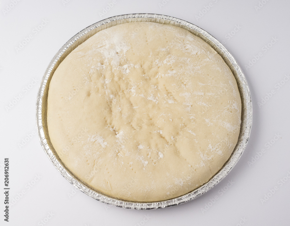 Raw pizza dough in its mold ready to bake Raw pizza dough in its mold ready to bake
