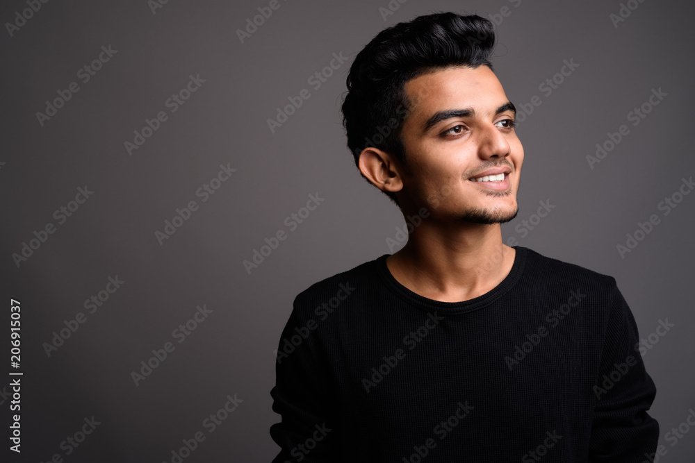 Fototapeta premium Young Indian man against gray background
