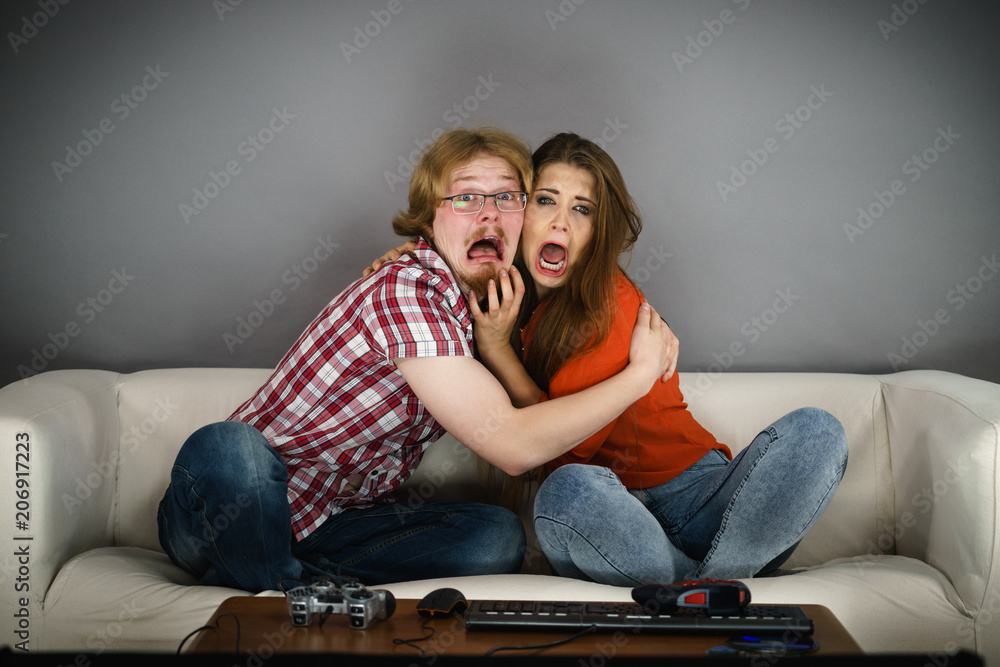 Naklejka premium Funny couple watching horror movie
