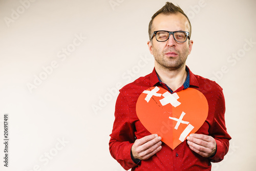 Adult man holding broken heart