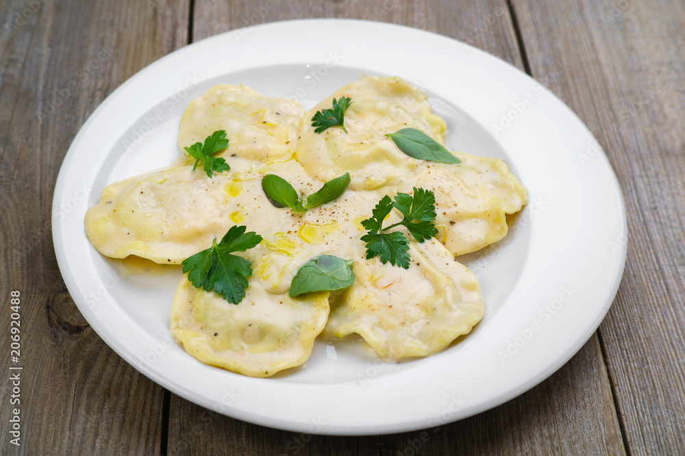 Italian national food, appetizing ravioli with bechamel sauce. Delicious restaurant food, Mediterranean cuisine concept Italian national food, appetizing ravioli with bechamel sauce. Delicious restaurant food, Mediterranean cuisine concept