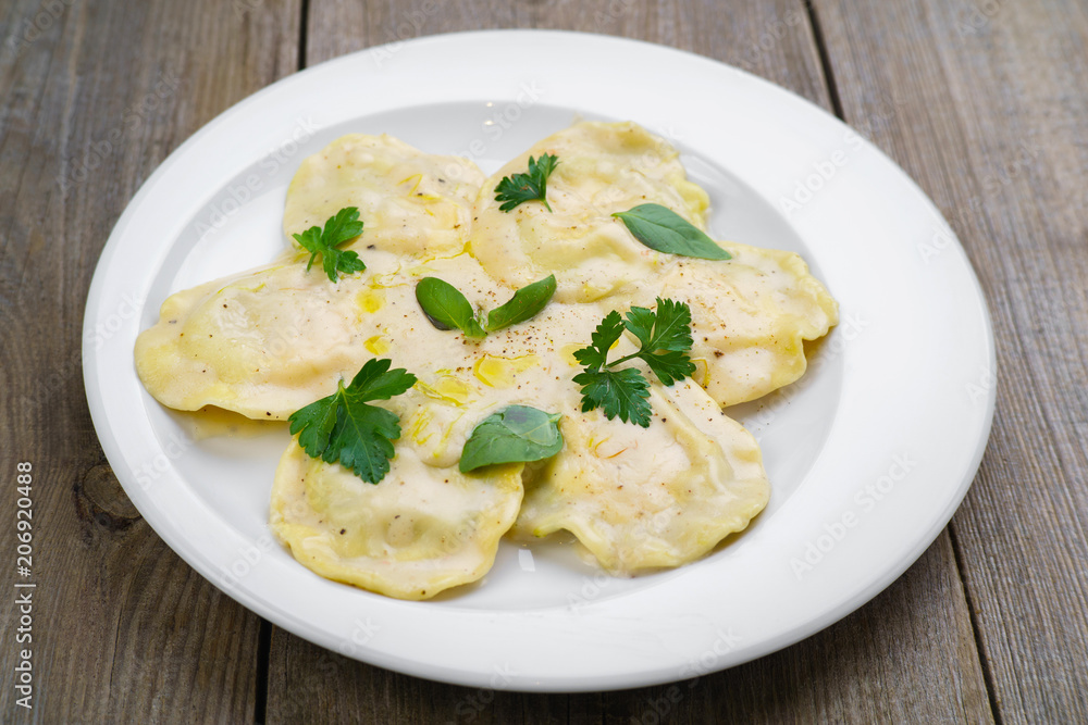 Italian national food, appetizing ravioli with bechamel sauce. Delicious restaurant food, Mediterranean cuisine concept