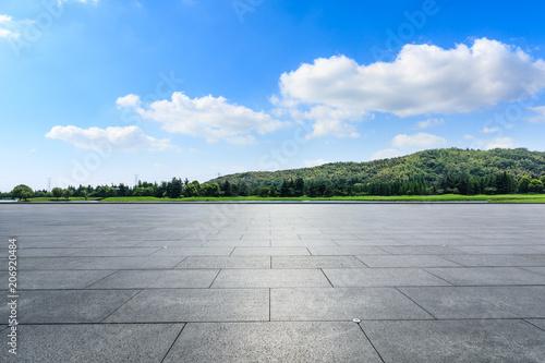 Empty square floor and hills with sky clouds