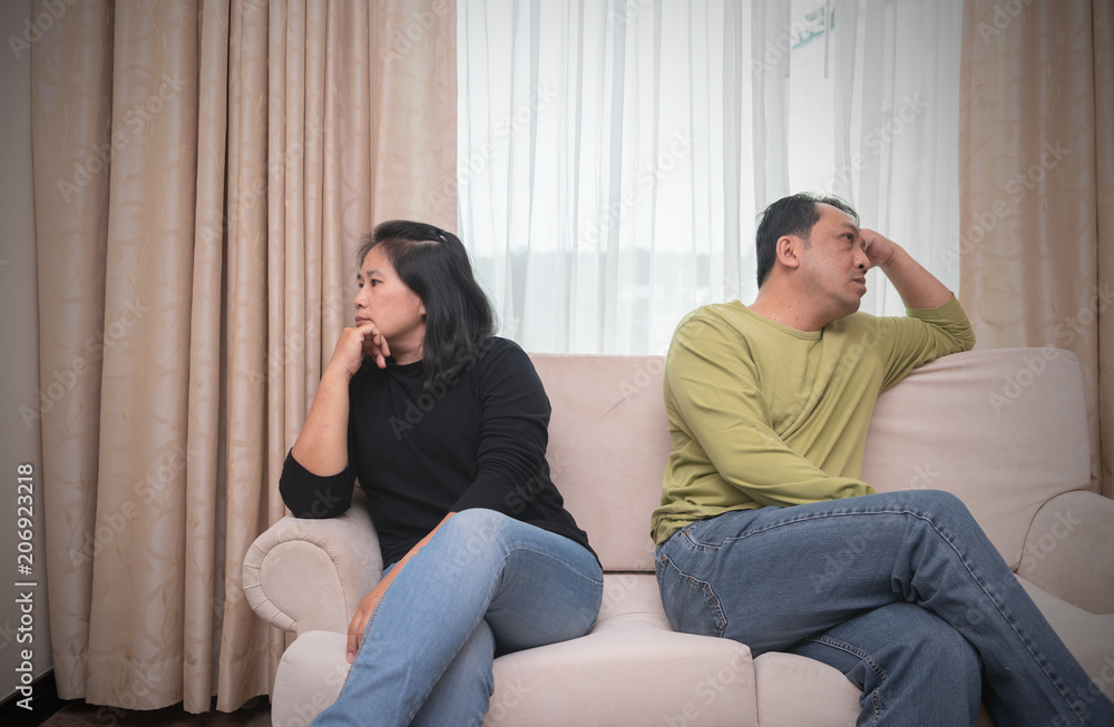 Husband and wife sitting on different sides of sofa. quarrel concept Husband and wife sitting on different sides of sofa. quarrel concept