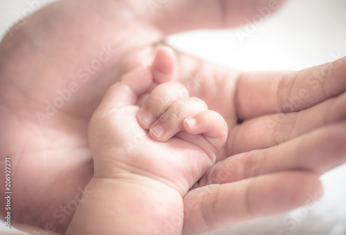  father holding baby hand in vintage tone style