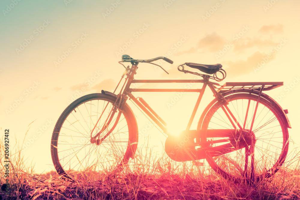 beautiful landscape image with Bicycle at sunset in vintage tone style